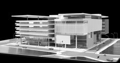 an architectural model of a building with cars parked in the parking lot next to it