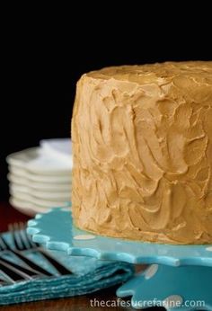 a frosted cake sitting on top of a blue plate