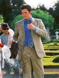 a man in a suit is spraying water on himself