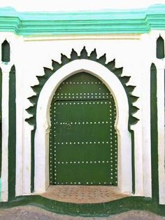 a green and white building with an arched door