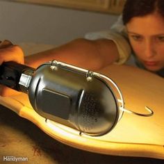 a woman laying on top of a surfboard next to a light that is turned on