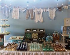 a baby shower dessert table with cupcakes, cookies and other items on it