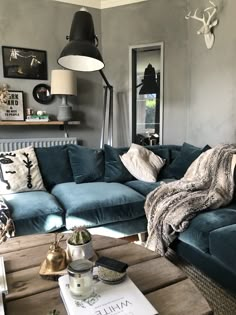 a living room filled with blue couches and pillows on top of a wooden table