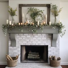 a fireplace with candles and greenery on the mantel above it is surrounded by wicker baskets