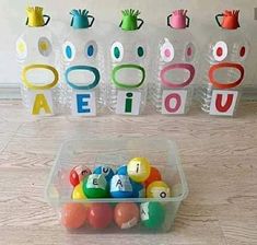 an assortment of colorful balls in a plastic container with letters and numbers on the side