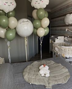 a baby in a crib surrounded by balloons