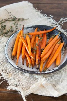 some carrots are on a plate with herbs