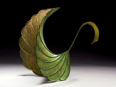 a green leaf shaped object on a black background