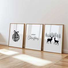 three framed christmas cards sitting on top of a wooden floor