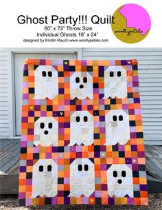 an orange and purple quilt with white ghost faces on it, in front of a garage door