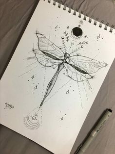 a drawing of a dragonfly sitting on top of a sheet of paper