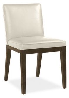 a white leather chair with dark wood legs