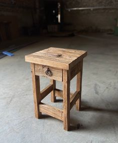 a small wooden table sitting on top of a cement floor