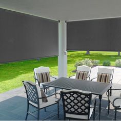 an outdoor dining area with grey shades on the windows and chairs around the table outside