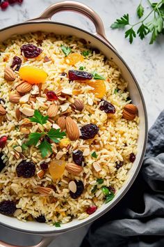 a pot filled with rice, nuts and dried cranberries on top of a table