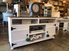 a white cabinet with lots of drawers and a clock on it's sideboard