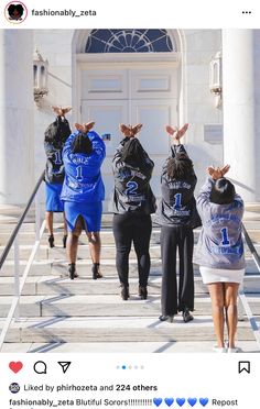 four people in hoodies are walking up the steps to a building with their backs turned towards each other