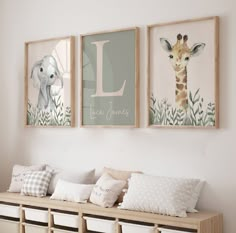 three framed pictures hang on the wall above a bench with storage bins underneath them