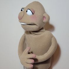 a stuffed monkey with one hand on its hip and the other pointing at it's back