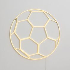 a light up soccer ball on a white surface with wires running through it and the bottom part of the ball visible