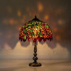 a stained glass lamp on a table in the corner of a room with white walls