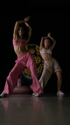 two women in pink and white dance on a black background