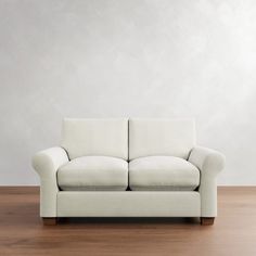 a white couch sitting on top of a wooden floor