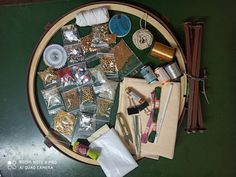 various crafting supplies laid out on a wooden tray with thread, scissors and other items