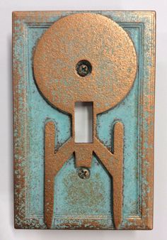 a decorative light switch plate with an iron design on it's cover and two holes in the middle