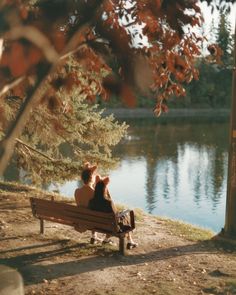 two people sitting on a bench near the water