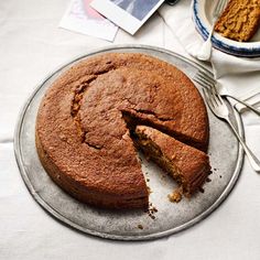 a cake that has been cut in half on a plate with a knife and fork next to it