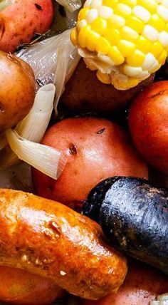 potatoes, corn on the cob, and other vegetables are piled up in a pile