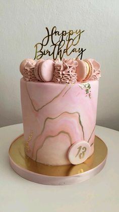 a pink marble birthday cake with gold accents