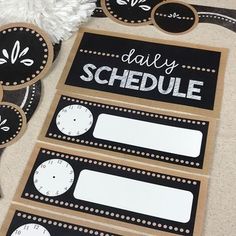 some black and white stickers with the words daily schedule written on them next to a pair of scissors