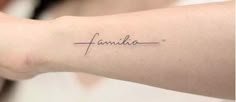 a woman's arm with the word family tattooed on her left arm, in cursive font