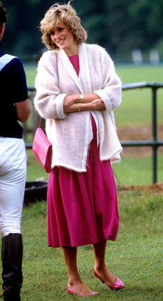 a woman in a pink dress standing next to a man wearing a white cardigan