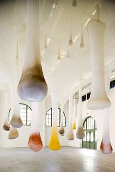 an empty room with several different colored objects hanging from the ceiling