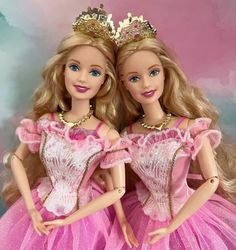 two barbie dolls are dressed in pink dresses and tiaras for a photo shoot together