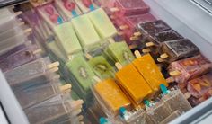 an assortment of different colored popsicles in a refrigerator