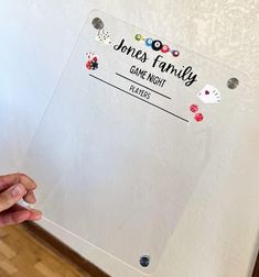 Family Game Night Tally Board - Customizable & Magnetic Bring your game nights to life with this customizable Family Game Night Tally Board! Keep track of each player's score in style with a sleek, magnetic acrylic board featuring fun game night elements like dice, cards, and poker chips. Easily store or display it out of the way on any magnetic surface, keeping your scoreboard accessible and organized. This board is perfect for families, game-loving couples, or newlyweds looking to start a new tradition. Choose additional game night elements to add a unique touch, each available for a small extra cost. Product Details: - Customizable with a family name - Magnetic acrylic board for easy out-of-the-way storage or display - Reusable dry-erase surface for convenient score tracking and easy cl Game Score Board, Game Night Board, Loving Couples, Jones Family, Acrylic Board, Game Nights, Poker Chips, Family Game Night