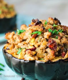 an eggplant filled with stuffing sitting on top of a blue plate next to another dish