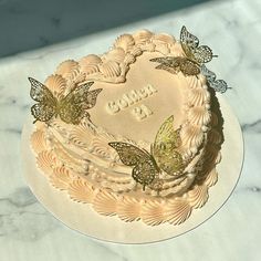 a heart shaped cake with butterflies on it