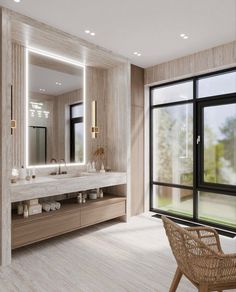 a bathroom with a large mirror, sink and wicker chair in front of it