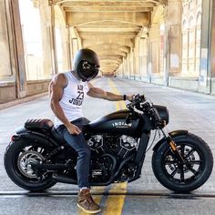 a man sitting on top of a black motorcycle