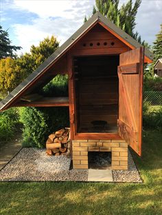 an outdoor bbq with wood stacked in the back and side door open to reveal it's outside space