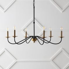 a chandelier hanging from the ceiling in a room with white walls and geometric designs