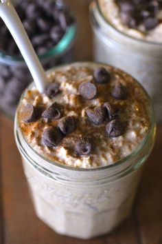 two jars filled with oatmeal and chocolate chips on top of a wooden table