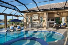 an indoor swimming pool with patio furniture and large glass doors leading to the back yard