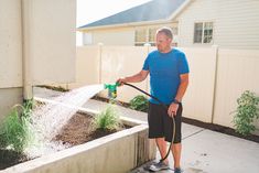 a man is watering his yard with a hose