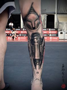 a man's leg with a black and grey tattoo on it